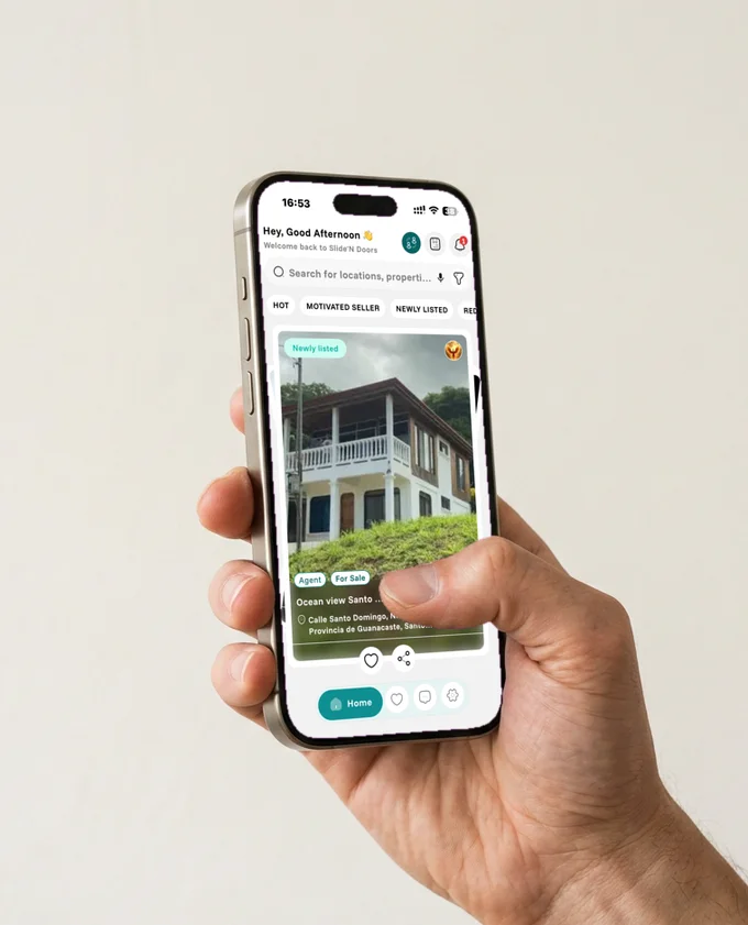 Slide’N Doors iPhone app showing a property listing, held in a hand